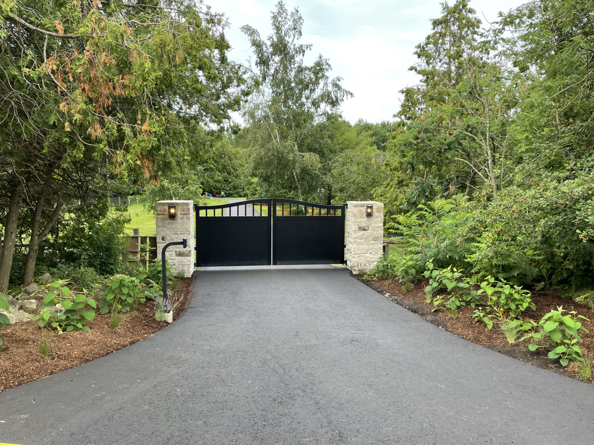 automatic driveway gate at driveway entrance on brick pillars